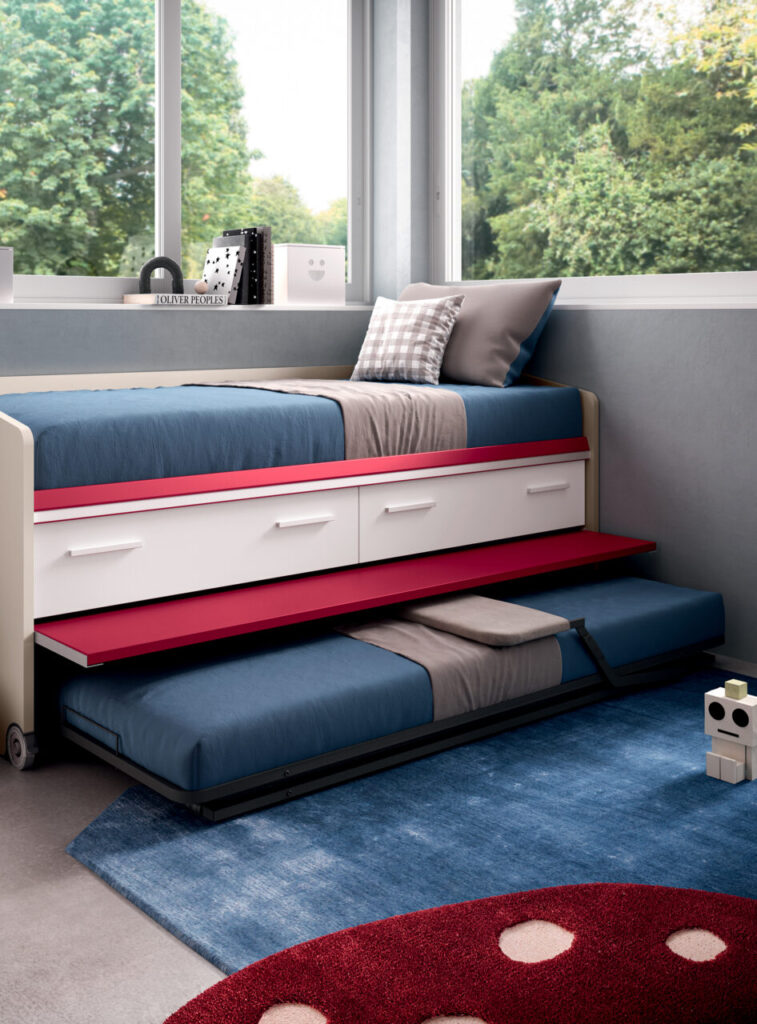 Letto trasformabile salvaspazio con secondo letto estraibile e cassetti contenitore, design moderno per cameretta, struttura bianca e rossa con biancheria blu e ambiente luminoso.